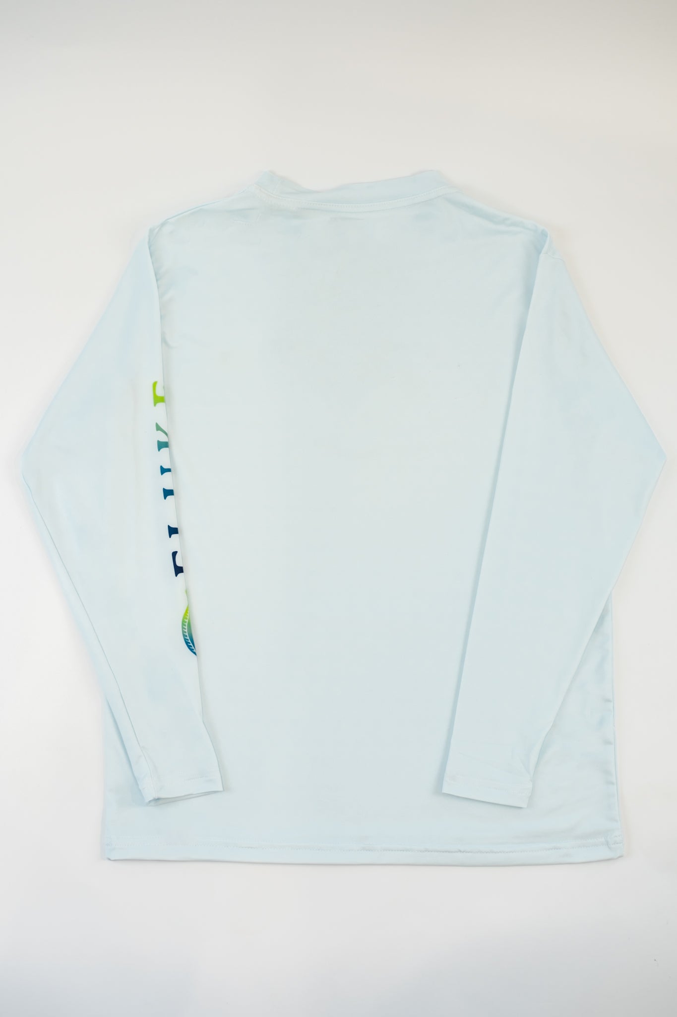 Light blue long-sleeve  Fluke shirt with a colorful logo on the sleeve against a dark gray background